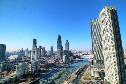 a view of a city with a river and skyscrapers at Shangri-La Tianjin in Tianjin