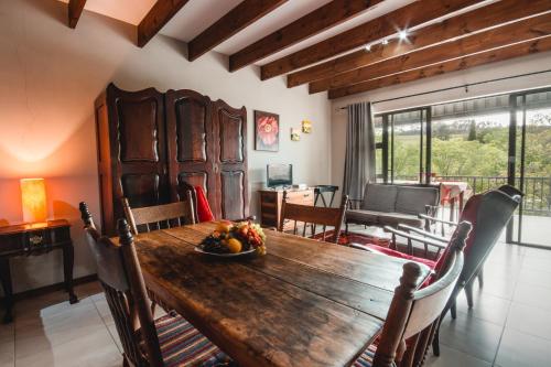 a dining room with a wooden table and chairs at Wildebraam Berry Estate in Swellendam