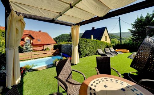 a patio with chairs and a table and a pool at Willa pod Czantorią SPA Ustroń in Ustroń