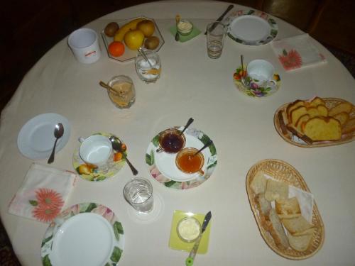 uma mesa branca com pratos de comida em Le Clos des Rosiers em Saint-Émilion