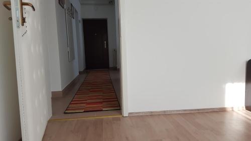 a hallway with a rug on the floor next to a door at Apartmani Ana in Szlatina