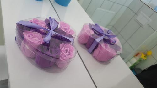 three pink cupcakes with purple bows on a counter at Apartmani Ana in Szlatina