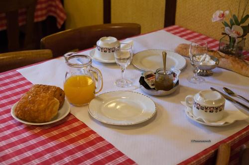 a table with plates of food and glasses of orange juice at Hôtel Restaurant Zum Schnogaloch in Obernai