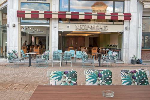 a group of chairs and tables in front of a restaurant at Morfeas Hotel in Argos