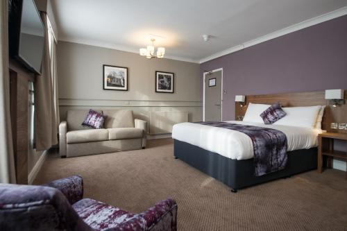 a hotel room with a bed and a couch at The Town House by Innkeeper's Collection in Norwich