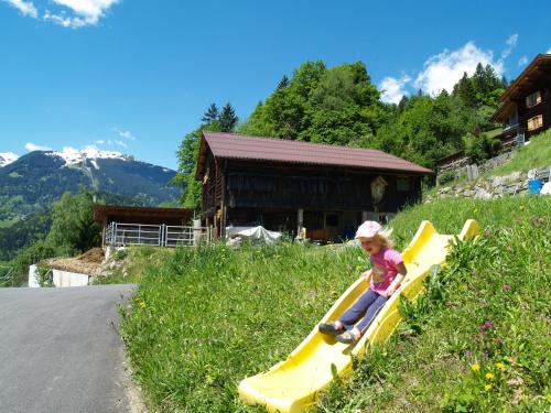 a little girl sitting on a yellow slide at Haus grüner Wald in Bartholomäberg