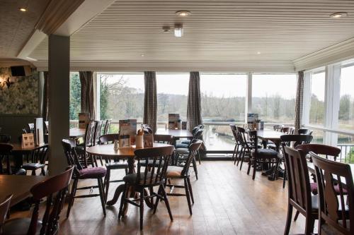 a restaurant with tables and chairs and a large window at The Town House by Innkeeper's Collection in Norwich