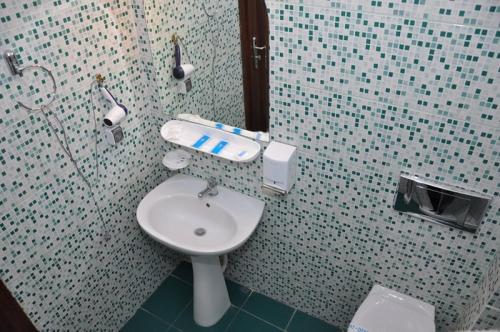 uma casa de banho com um WC e um lavatório em Hotel Coliseum em Calafat
