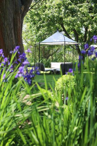 a gazebo in a garden with purple flowers at Landhaus am See in Garbsen