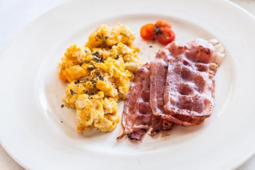 a plate of breakfast food with bacon and scrambled eggs at Hostal Antolín in Redondela