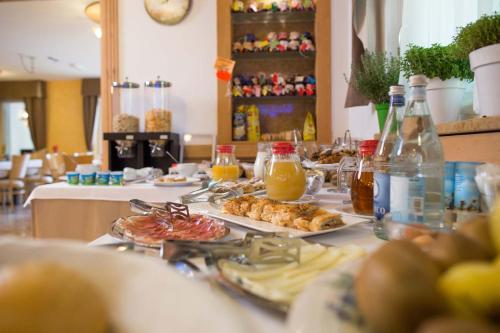 a table topped with plates of food and drinks at Residence Hotel Miralago in Pergine Valsugana