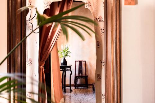 a hallway with curtains and a table with a plant at Novecento Boutique Hotel in Venice