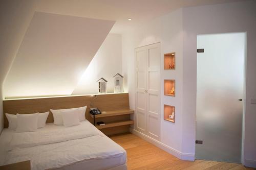 a bedroom with a white bed and a white wall at Landhaus am See in Garbsen