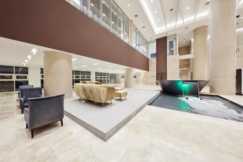 a lobby with a pool and a table and chairs at Skybay Hotel Gyeongpo in Gangneung