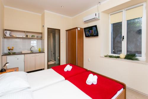 Un dormitorio con una cama con dos zapatos blancos. en Villa Iveta, en Dubrovnik