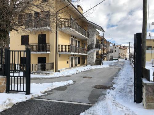 an empty street with snow in front of buildings at Appartamento in residence Ovindoli in Ovindoli