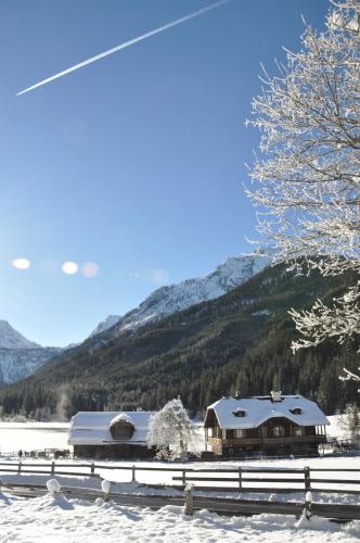 a house in the snow next to a mountain at Chalet Freiraum in Kleinarl