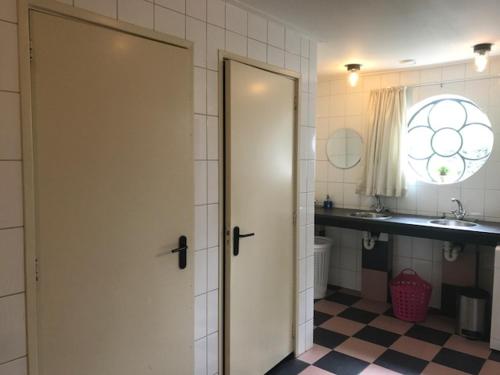 baño con puerta blanca y lavamanos en Theaterwerkplaats private appartment, en Kantens