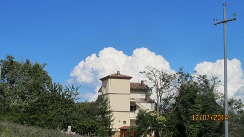 a building on a hill with clouds in the sky at Locanda San Marino Al Coppo in Monte Grimano Terme