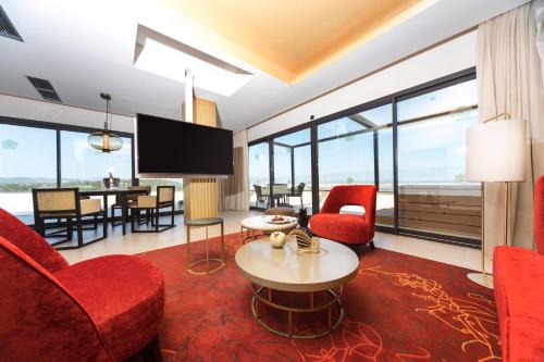 a living room with red chairs and a tv at GPRO Valparaiso Palace & Spa in Palma de Mallorca