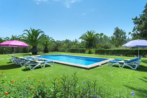 una piscina con 2 sillas y 2 sombrillas en Owl Booking Villa Bobis - Family Holidays with Private Pool, en Port de Pollença (Puerto Pollensa)