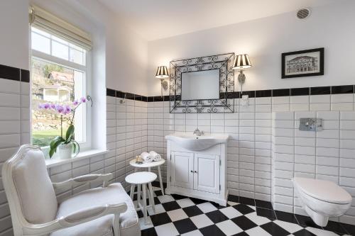 a white bathroom with a sink and a mirror at Pałacyk Szklarska in Piechowice