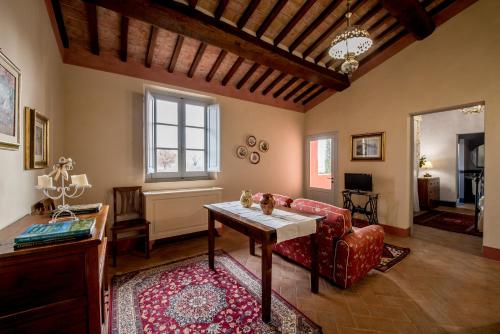 a living room with a red couch and a table at Agriturismo Podere La Rocca in Abbadia di Montepulciano