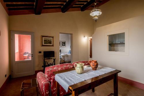 a living room with a red couch and a table at Agriturismo Podere La Rocca in Abbadia di Montepulciano