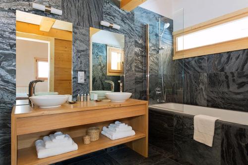 a bathroom with two sinks and a tub and a mirror at Chalet Isabelle Mountain lodge 5 star 5 bedroom en suite sauna jacuzzi in Chamonix-Mont-Blanc