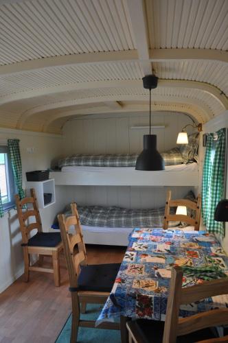 a dining room with a table and chairs and a bed at Your nice waggon at the Cow's Paradise in Amsterdam