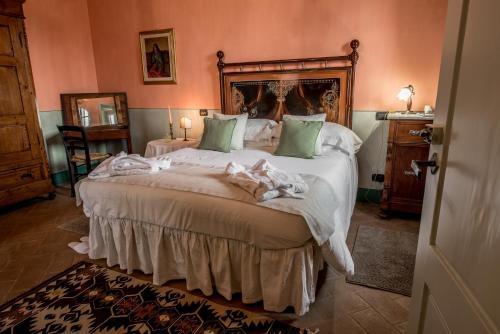 a bedroom with a large bed with green pillows at Agriturismo Podere La Rocca in Abbadia di Montepulciano