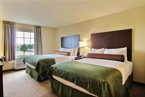 a hotel room with two beds and a window at AmeriVu inn and Suites - Crookston in Crookston