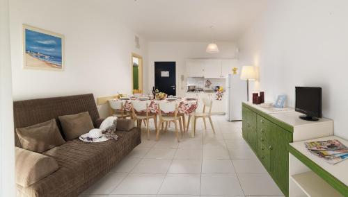 uma sala de estar e cozinha com um sofá e uma mesa em Isaresidence Holiday Resort em Ca Lino