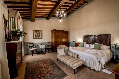 アッバディーア・ディ・モンテプルチャーノにあるAgriturismo Podere La Roccaの広いベッドルーム(ベッド2台、ソファ付)