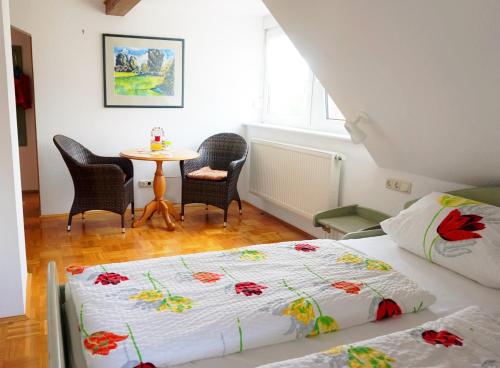 a bedroom with two beds and a table with chairs at Gasthaus Zur Krone in Windelsbach