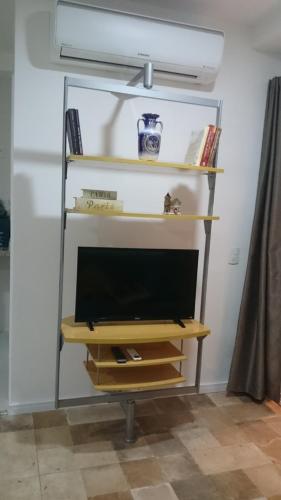 a tv sitting on a shelf in a room at Studio mobiliado in Santos