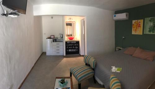 um pequeno quarto com uma cama e uma cadeira em Complejo El Faro em Santa Rosa de Calamuchita