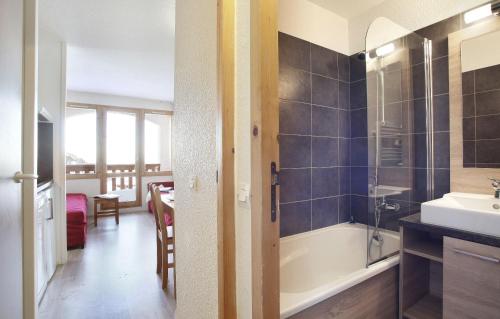 a bathroom with a bath tub and a sink at Résidence Odalys La Licorne in La Plagne