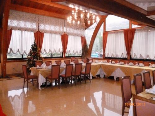 a dining room with a christmas tree and tables and chairs at Hotel Marinella in Pizzo