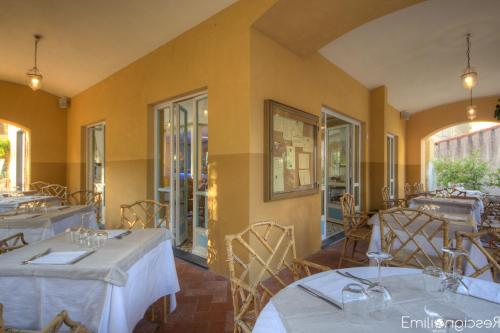 a dining room with tables and chairs and windows at Hotel Arabesque in Varigotti