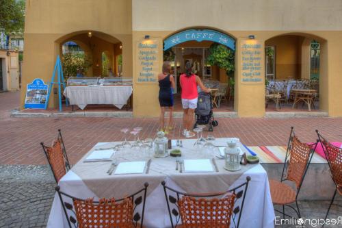 two people standing at a table in front of a restaurant at Hotel Arabesque in Varigotti