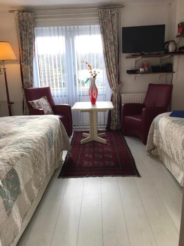 a bedroom with a bed and a table and chairs at Villa 't Haasduin in Wijk aan Zee