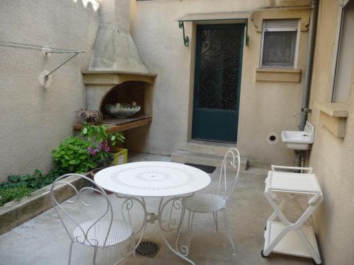 d'une terrasse avec une table et des chaises devant une porte. dans l'établissement Havre de Paix Centre ville Narbonne, T3 confortable, près de l'ARENA et du GRAND BUFFET, à Narbonne