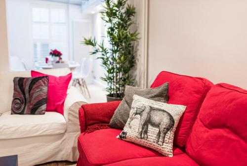 ロンドンにあるChelsea London Town Houseのリビングルーム(赤いソファ、枕付)