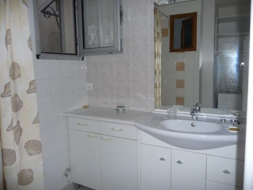 uma casa de banho branca com um lavatório e um espelho em Havre de Paix Centre ville Narbonne, T3 confortable, près de l'ARENA et du GRAND BUFFET em Narbona