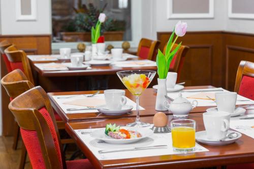 a dining room with tables with food and flowers on them at Residence Romanza in Mariánské Lázně