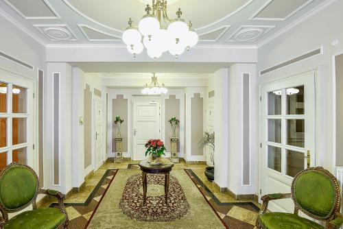 a hallway with a table and chairs and a chandelier at Residence Romanza in Mariánské Lázně
