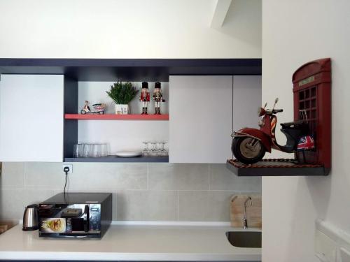 a kitchen with a counter with a scooter on a shelf at Eye of London @ Central Malacca in Melaka
