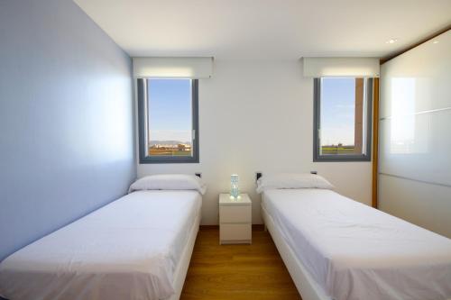 two beds in a room with two windows at Sa Pobla 185385 in Sa Pobla