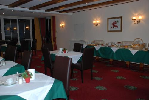 a dining room with tables with green table cloth at Landhaus Brieger in Henndorf am Wallersee